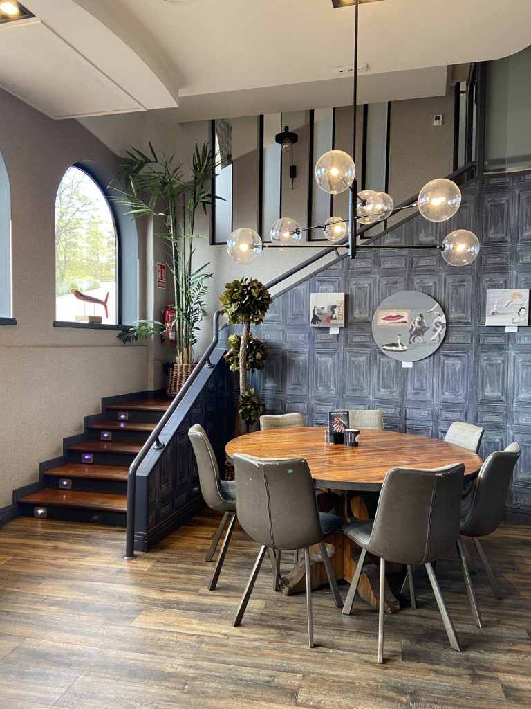 Mesa redonda al lado de unas escaleras en una cafetería